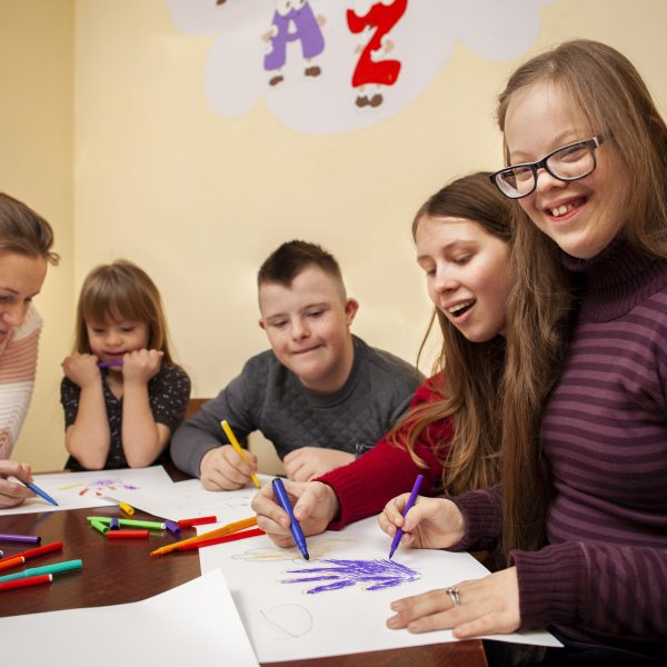happy-girl-with-down-syndrome-posing-while-drawing